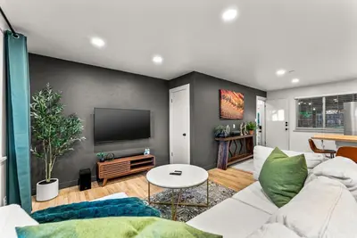 a living room with a white couch and a tv at Arvada Hotspot Modern Vibes Sauna and Games in Arvada