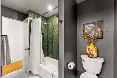 a bathroom with a toilet and a shower with a vase at Arvada Hotspot Modern Vibes Sauna and Games in Arvada