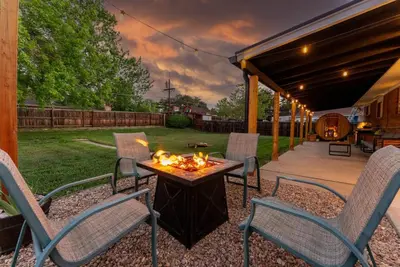 a patio with chairs and a table with a fire pit at Arvada Hotspot Modern Vibes Sauna and Games in Arvada