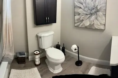 a bathroom with a toilet and a painting on the wall at The Urban Roost I A Rustic City Escape in Denver