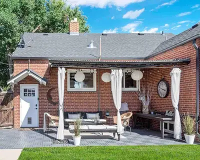 a brick house with white curtains and a bench at The Urban Roost I A Rustic City Escape in Denver