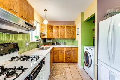 a kitchen with wooden cabinets and white appliances at Less Than 1 Mi to CU Boulder Home with Fenced Yard! in Boulder