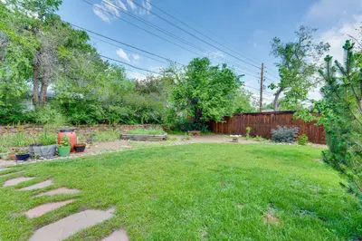 a yard with a backyard with a fence and grass at Less Than 1 Mi to CU Boulder Home with Fenced Yard! in Boulder