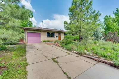 a house with a purple garage in a yard at Less Than 1 Mi to CU Boulder Home with Fenced Yard! in Boulder