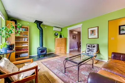 a living room with green walls and a wood stove at Less Than 1 Mi to CU Boulder Home with Fenced Yard! in Boulder