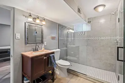 a bathroom with a shower and a toilet and a sink at Central Huge Duplex - Sleeps 16 in Wheat Ridge