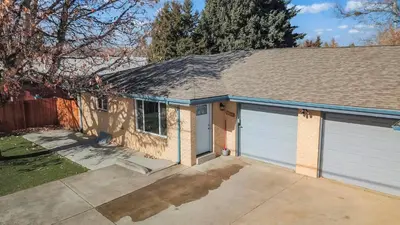 a house with two garage doors in a driveway at Central Huge Duplex - Sleeps 16 in Wheat Ridge