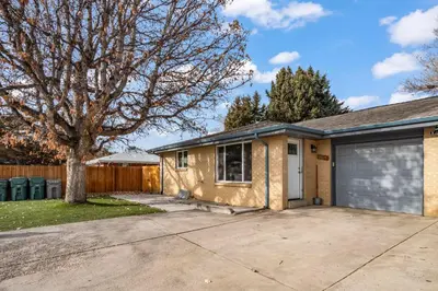 a house with a garage and a tree at Central Huge Duplex - Sleeps 16 in Wheat Ridge