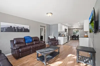 a living room with a leather couch and a table at Central Huge Duplex - Sleeps 16 in Wheat Ridge