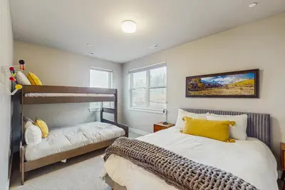 a bedroom with two beds with yellow pillows at Modern Mountain View in Fraser