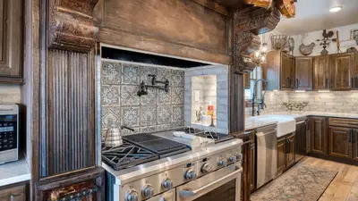 a kitchen with a stove and a sink at Winterhaven Estate by AvantStay Sleeps 19 Guests Mountain Compound w Views Firepit Hot Tub in Winter Park