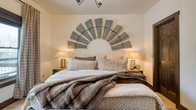 a bedroom with a large bed and a window at Winterhaven Estate by AvantStay Sleeps 19 Guests Mountain Compound w Views Firepit Hot Tub in Winter Park