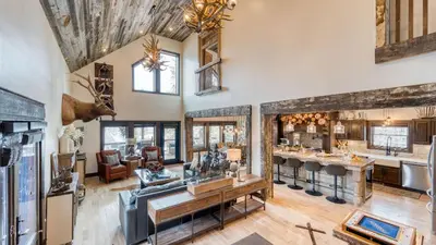 an open kitchen and living room in a house at Winterhaven Estate by AvantStay Sleeps 19 Guests Mountain Compound w Views Firepit Hot Tub in Winter Park