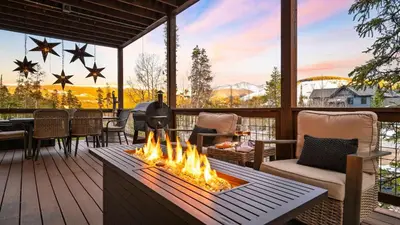 a patio with a fire pit on a deck at Winterhaven Estate by AvantStay Sleeps 19 Guests Mountain Compound w Views Firepit Hot Tub in Winter Park