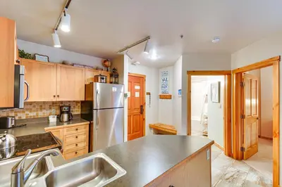 a kitchen with a stainless steel refrigerator and wooden cabinets at On-Site Gondola Access Keystone Ski Condo in Keystone