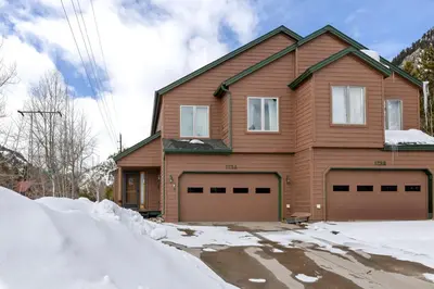 a house with two garage doors in the snow at Charming Frisco Getaway. Close to Main St. Sleeps 8 in Frisco