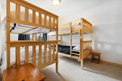 two bunk beds in a room with a table at Charming Frisco Getaway. Close to Main St. Sleeps 8 in Frisco