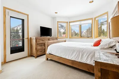 a bedroom with a bed and a tv and windows at Charming Frisco Getaway. Close to Main St. Sleeps 8 in Frisco