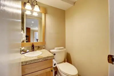 a bathroom with a toilet and a sink and a mirror at 1250 Willow Grove townhouse in Silverthorne