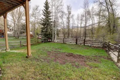 a yard with a wooden fence and a field at 1250 Willow Grove townhouse in Silverthorne