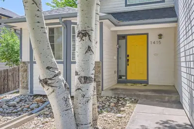 a house with a yellow door and some trees at Sleeps 9 - Family Retreat - Scenic Trails - Views in Erie