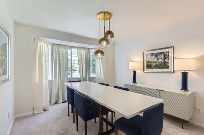 a dining room with a white table and blue chairs at Sleeps 9 - Family Retreat - Scenic Trails - Views in Erie