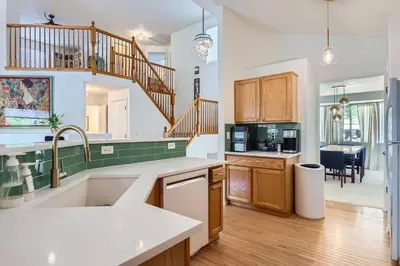 a kitchen with wooden cabinets and a staircase at Sleeps 9 - Family Retreat - Scenic Trails - Views in Erie