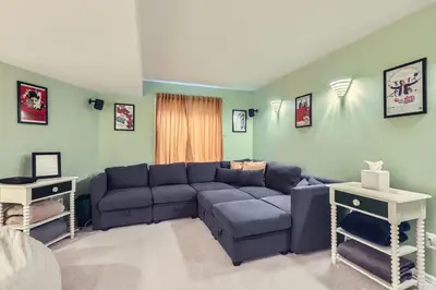 a living room with a blue couch and two tables at Sleeps 9 - Family Retreat - Scenic Trails - Views in Erie