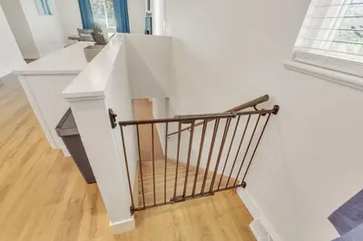 a white staircase with a metal hand rail at Vacation Launch Pad - Great for Groups in Arvada