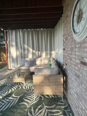 a couch sitting in a screened in porch with a clock at Entire Private Garden-Level Retreat in Englewood