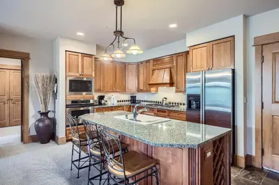 a kitchen with wooden cabinets and a large island with bar stools at Lone Eagle 3013 condo in Keystone
