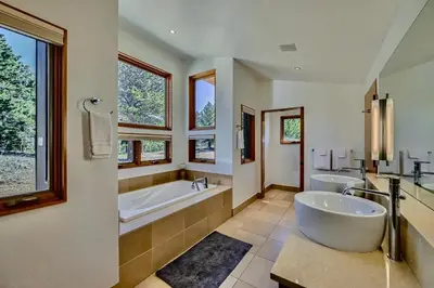 a large bathroom with two sinks and a tub and a large tubermott at Caribou Ridge with Hot Tub! Pet Friendly with James Peak Views - Sleeps 10 in Nederland