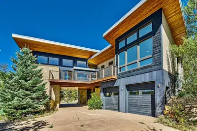 an exterior view of a house with a garage at Caribou Ridge with Hot Tub! Pet Friendly with James Peak Views - Sleeps 10 in Nederland