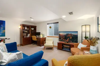 a living room with a blue couch and a tv at Rigden Retreat Garage, Dog Friendly, Near Trails in Fort Collins