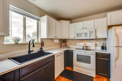 a kitchen with white cabinets and a sink and a window at 1 Mi to Dtwn Estes Park Mtn-View Haven! in Estes Park