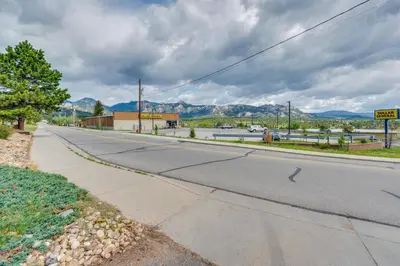 an empty street with mountains in the background at 1 Mi to Dtwn Estes Park Mtn-View Haven! in Estes Park