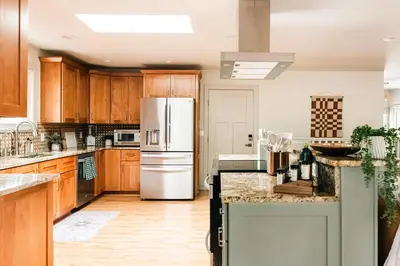 a kitchen with wooden cabinets and a white refrigerator at Wellness Retreat - Sauna Cold Plunge & Hot Tub in Broomfield