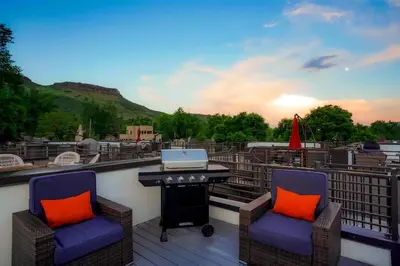 a balcony with two chairs and a table with a laptop at Million Dollar Rooftop MTN Views -2 King Beds-DT Golden in Golden