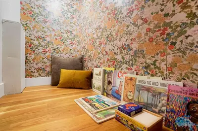 a room with books on the floor and a wall with flowers at Million Dollar Rooftop MTN Views -2 King Beds-DT Golden in Golden