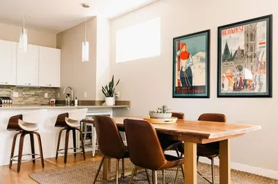 a kitchen and dining room with a wooden table and chairs at Modern Comfort w Mountain Views - Pet-Friendly in Denver