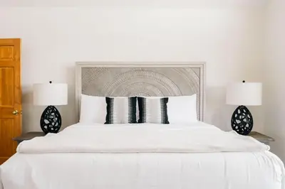 a bedroom with a large white bed with two lamps at Peaceful Getaway with Hot Tub - Views - Evergreen in Evergreen