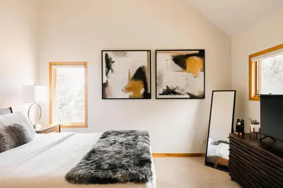 a bedroom with a bed and three paintings on the wall at Peaceful Getaway with Hot Tub - Views - Evergreen in Evergreen