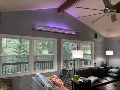 a living room with a couch and windows with purple lighting at Peaceful in Evergreen