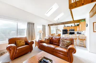 a living room with leather furniture and a kitchen at Buffalo Ridge 305E in Silverthorne