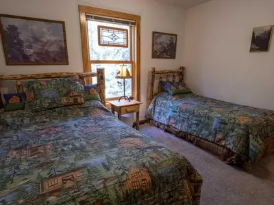 a bedroom with two beds and a window at Columbine Cabin, 0019 in Grand Lake