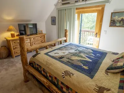 a bedroom with a wooden bed and a television at Columbine Cabin, 0019 in Grand Lake