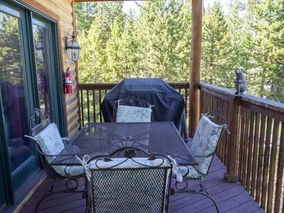 a table and chairs sitting on a porch with at Columbine Cabin, 0019 in Grand Lake