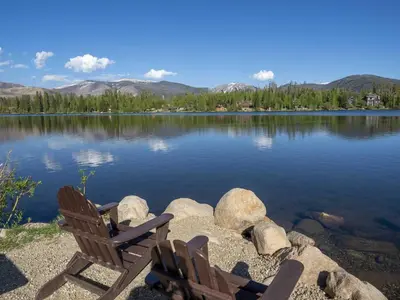 two chairs sitting on the shore of a lake at Columbine Cabin, 0019 in Grand Lake
