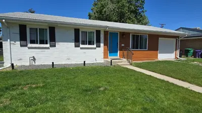a small house with a grass yard in front of it at Alanas house in Denver