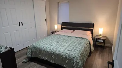 a bedroom with a bed and two lamps on two tables at Alanas house in Denver